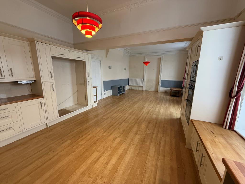 Lot: 133 - SIX SELF-CONTAINED FLATS IN BLOCK WITH STRUCTURAL ISSUES ON A LARGE PLOT WITH POTENTIAL - Looking back through the kitchen to the dining area
